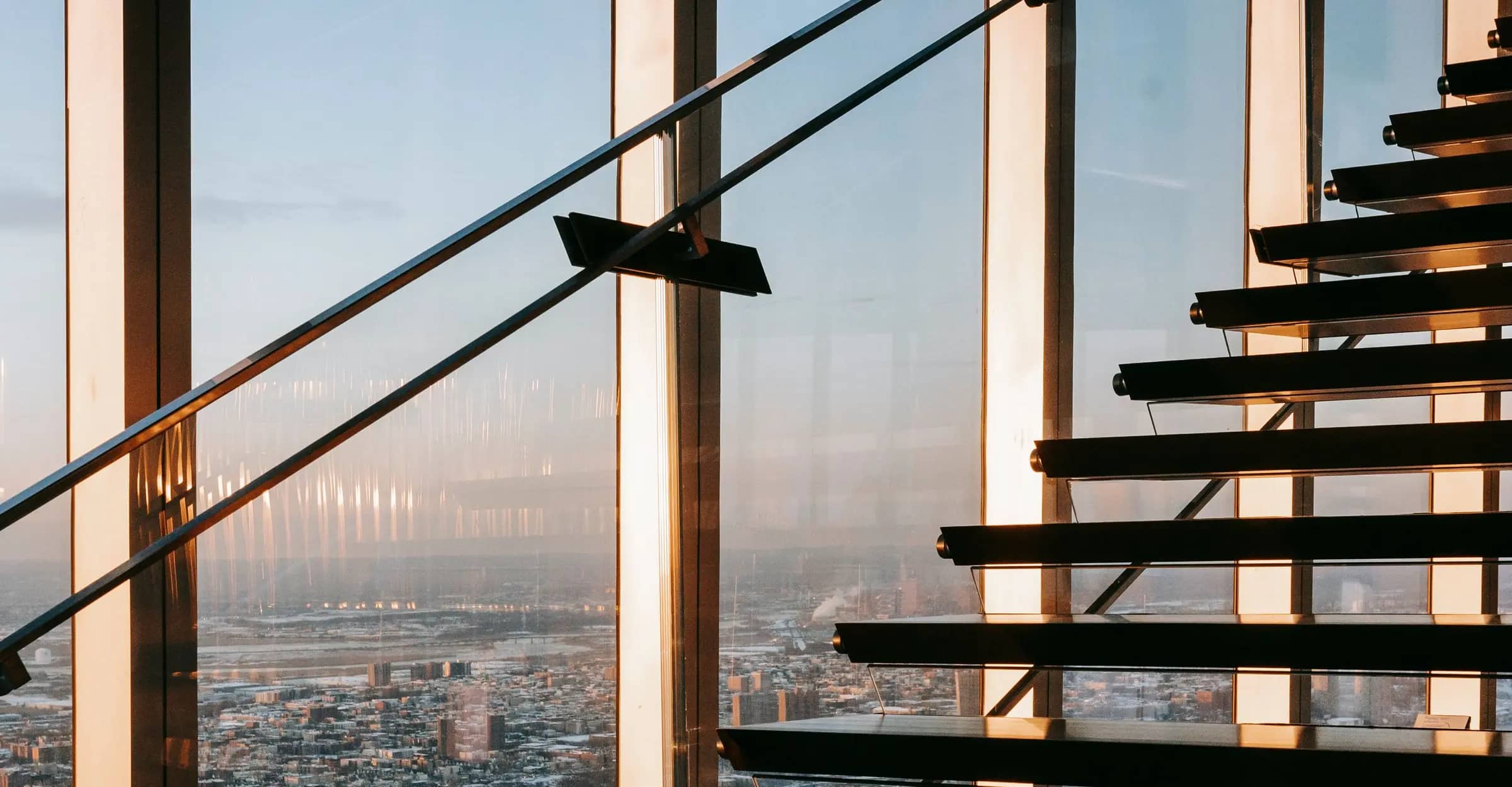 Glass-fronted staircase overlooking the city inside a tower